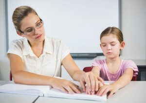 Photo: Teacher assisting blind student in library