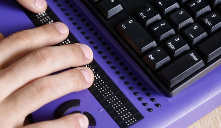 Photo: Blind person using a Braille display